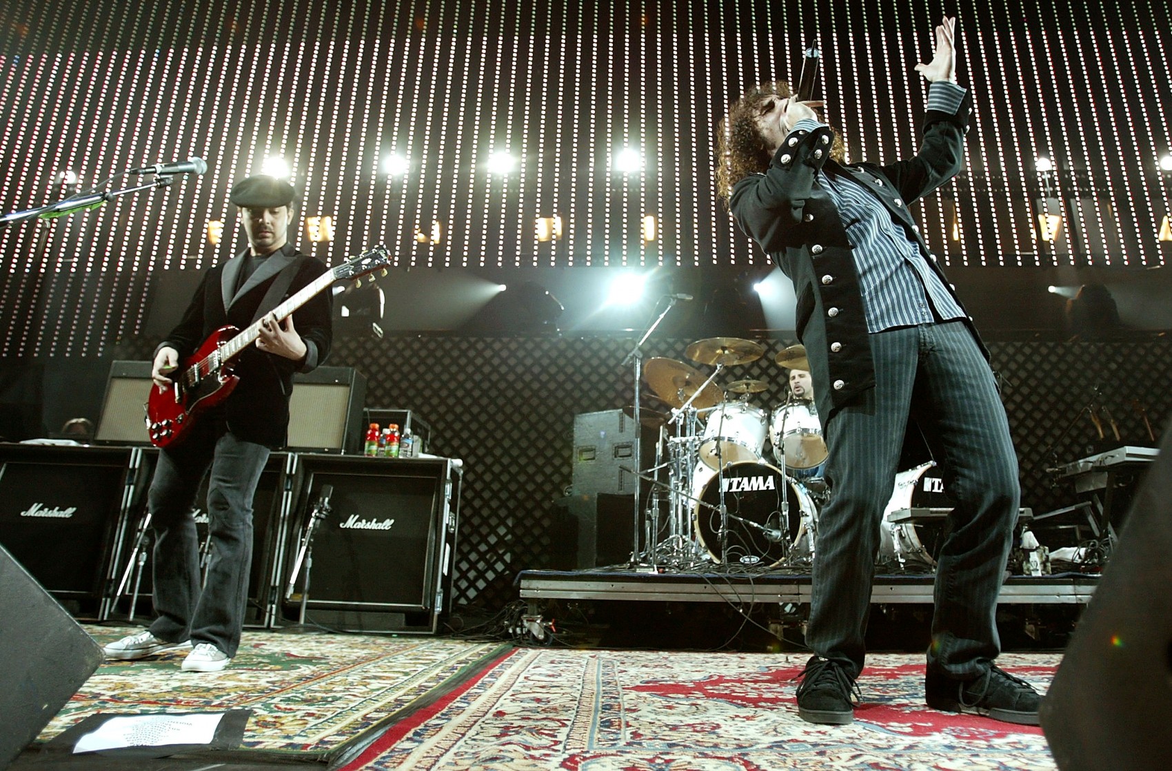 LOS ANGELES - DECEMBER 10:  Guitarist Daron Malakian, drummer John Dolmavan, and lead singer Serj Tankian of System Of A Down performs at 106.7 KROQ's "Almost Acoustic Christmas" at Gibson Ampitheater at Universal Studios on December 10, 2005 in Los Angeles, California.  (Photo by Karl Walter/Getty Images)