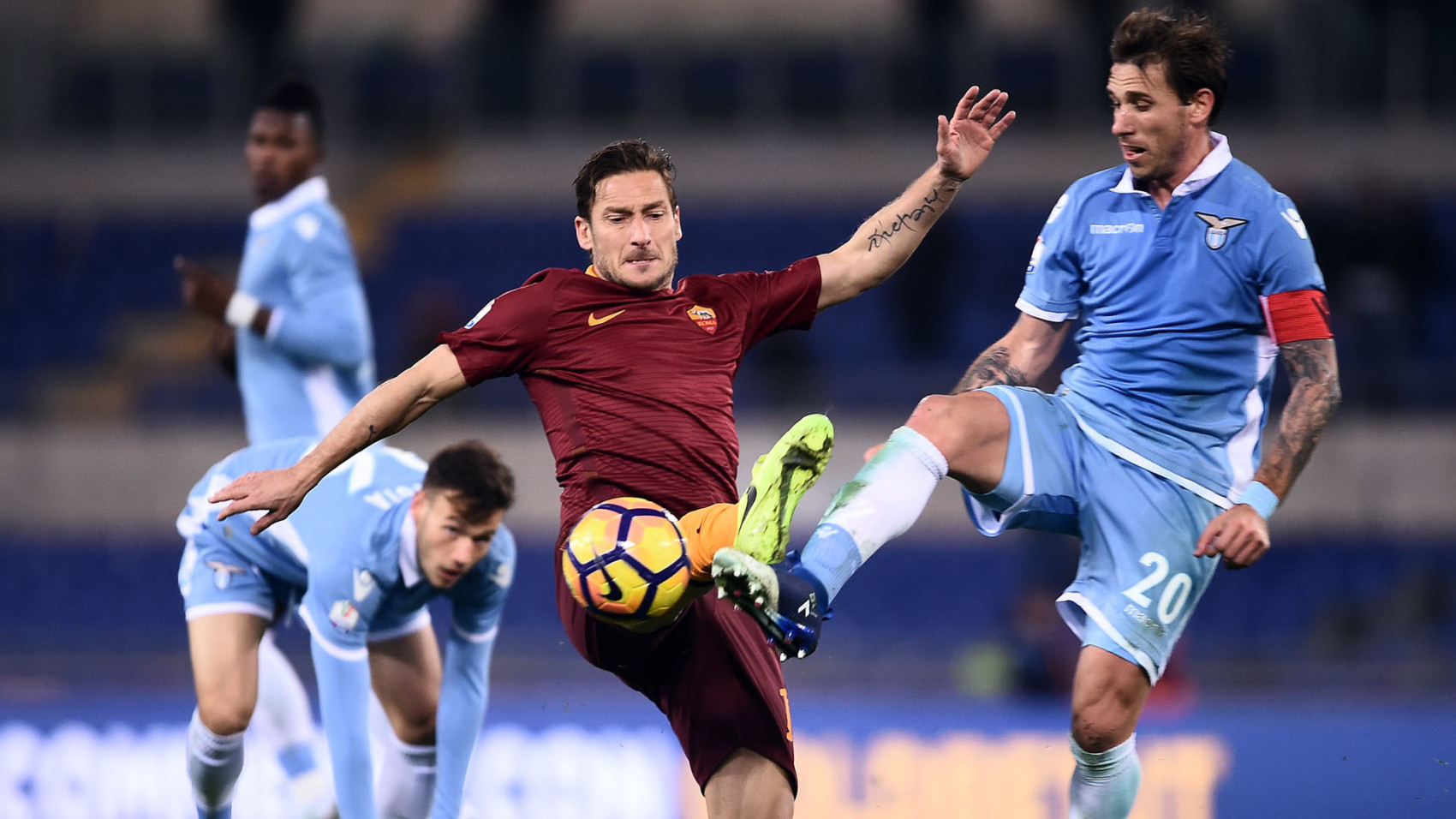 Roma's forward from Italy Francesco Totti (C) vies with Lazio's midfielder from Argentina Lucas Biglia during the Italian TIM Cup 1st leg semifinal football match on March 1, 2017 at the Olympic stadium in Rome.  / AFP PHOTO / FILIPPO MONTEFORTE        (Photo credit should read FILIPPO MONTEFORTE/AFP/Getty Images)