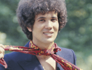 Il cantautore italiano Lucio Battisti si allaccia sorridente un foulard al collo. 1969